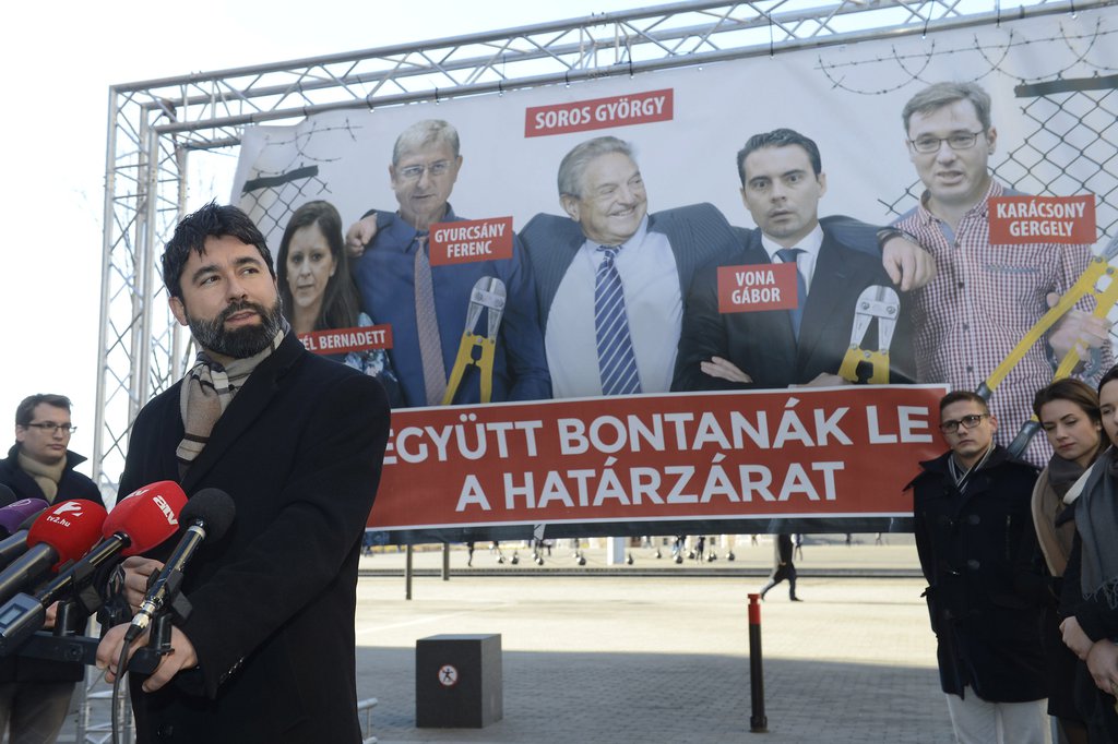 Hidvéghi Balázs, a Fidesz kommunikációs igazgatója büszkén mutatja be Az ellenzék lebontaná a határzárat címmel elkészült plakátot Budapesten, az Alkotmány utcában 2018. január 30-án -  MTI Fotó: Soós Lajos