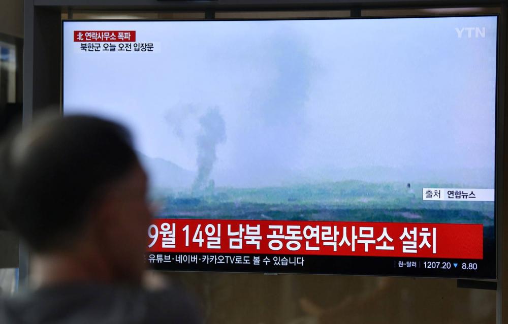 Egy dél-koreai férfi nézi a híradóban a robbantásról szóló híreket