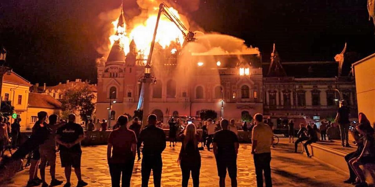 Járókelők nézik, fotózzák a lángoló püspöki palotát