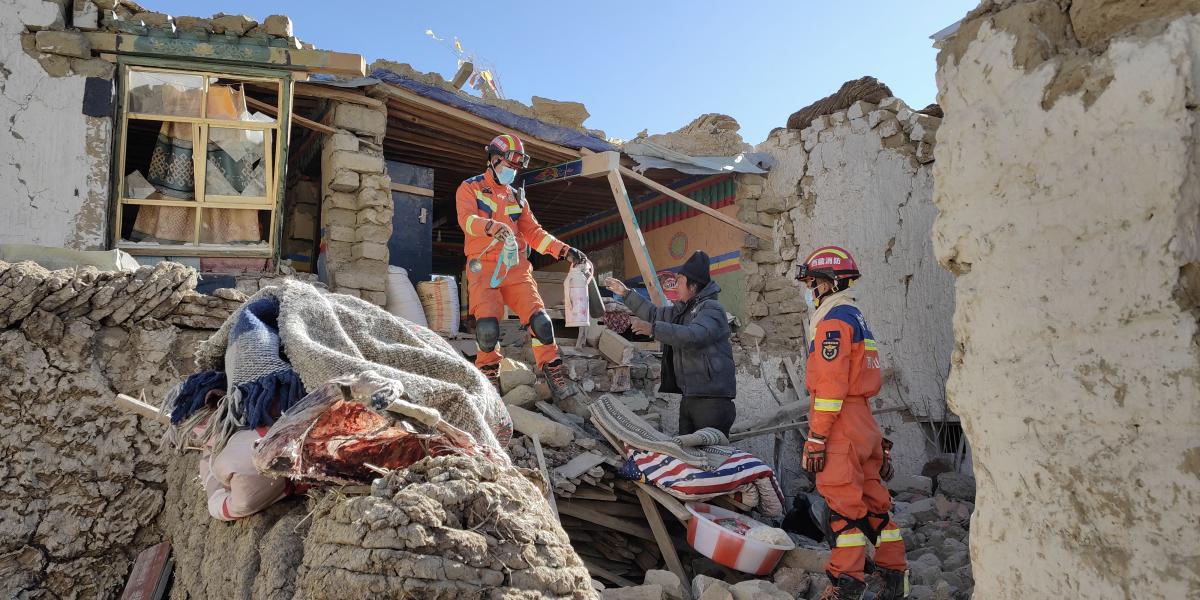 A kutató-mentőcsapat tagjai mentik egy lakos ingóságait a romok közül a január 8-i erős földrengést követően Tibetben