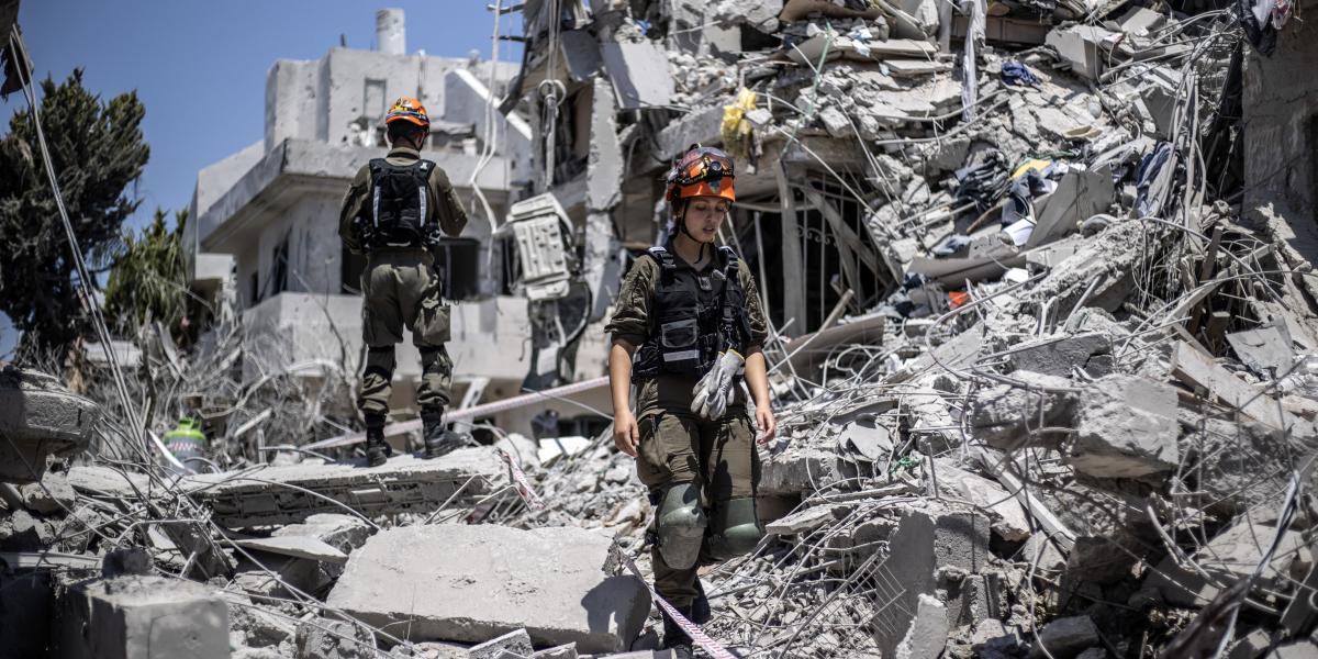 Kutatási és mentési munkálatok izraeli épületek romjai között az iráni rakétatámadások után 2025. június 14-én.