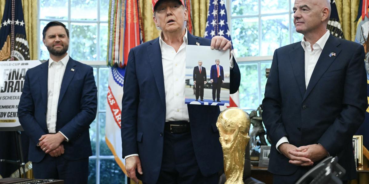 Donald Trump amerikai elnök a Fehér Házban, Gianni Infantino FIFA-elnök jelenlétében felmutat egy fotót, amely róla és az orosz elnökről készült Alaszkában