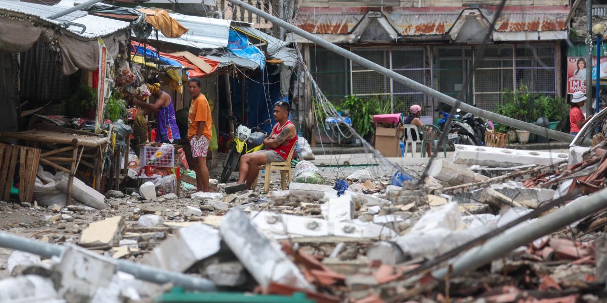 Heli lakosok a törmelékek és megrongált épületek közelében a 6,9-es erősségü földrengés után Bogo városában, a Fülöp-szigeteken, 2025. október 1-jén. 
