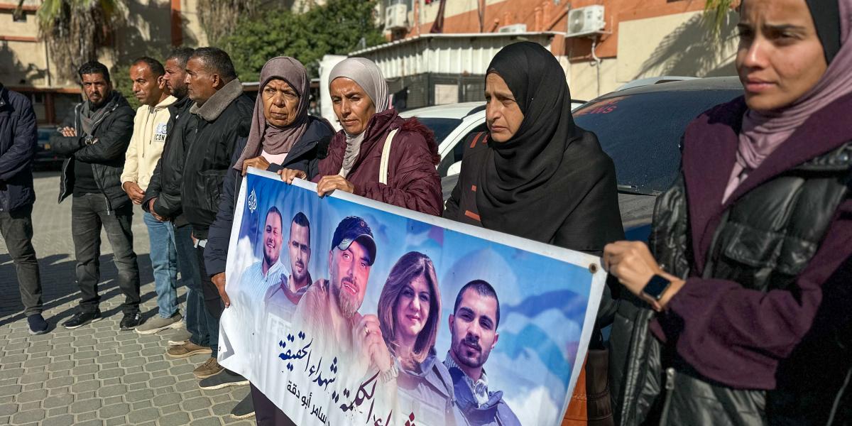 Újságírók és családtagok meggyilkolt sajtómunkások fényképeivel ellátott plakátokat tartanak az Al Jazeera palesztin operatőre, Samer Abu Daqqa emlékére rendezett megemlékezésen halálának második évfordulóján, 2025. december 15-én a Gázai övezetben találh