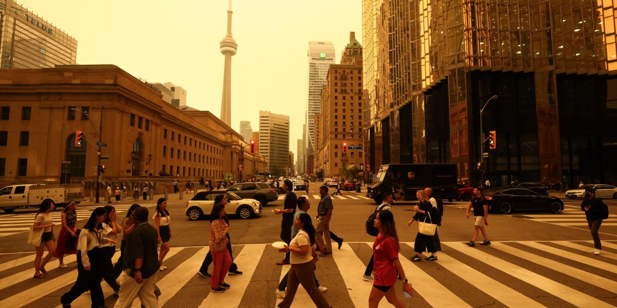 Emberek sétálnak Toronto belvárosában, 2026. július 15-én, miközben az észak-ontariói erdőtüzek füstje rossz levegőminőséget okoz a városban