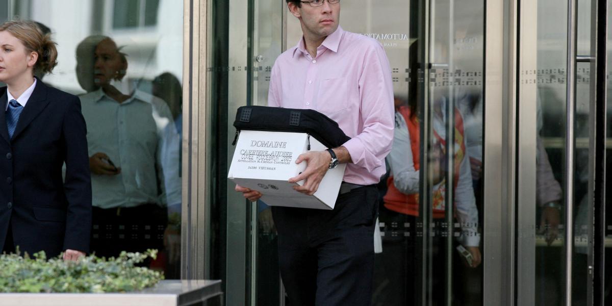 Egy dobozzal a kezében lévő férfi elhagyja a Lehman Brothers európai központját a kelet-londoni Canary Wharf-on, 2008. szeptember 15-én