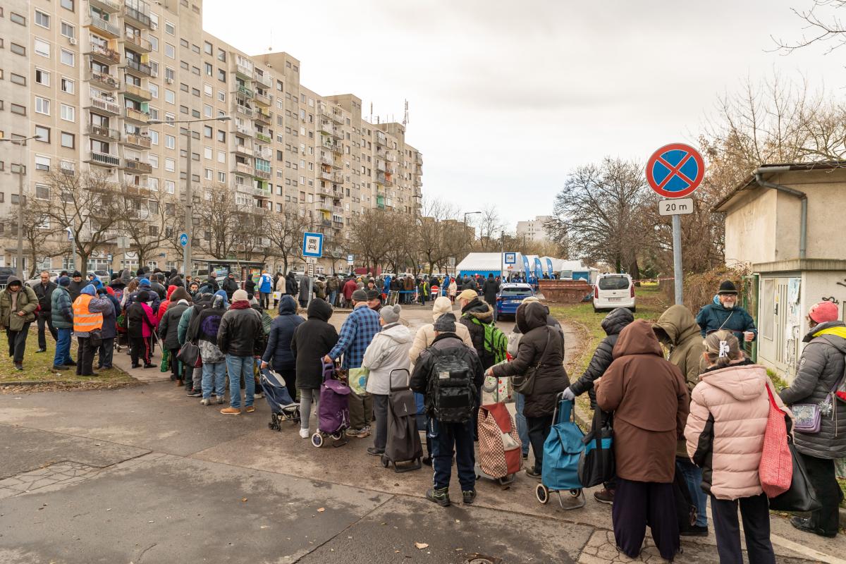 Szülők, gyerekek, idősek állnak hosszú sorokban a magyarországi ételosztásokon