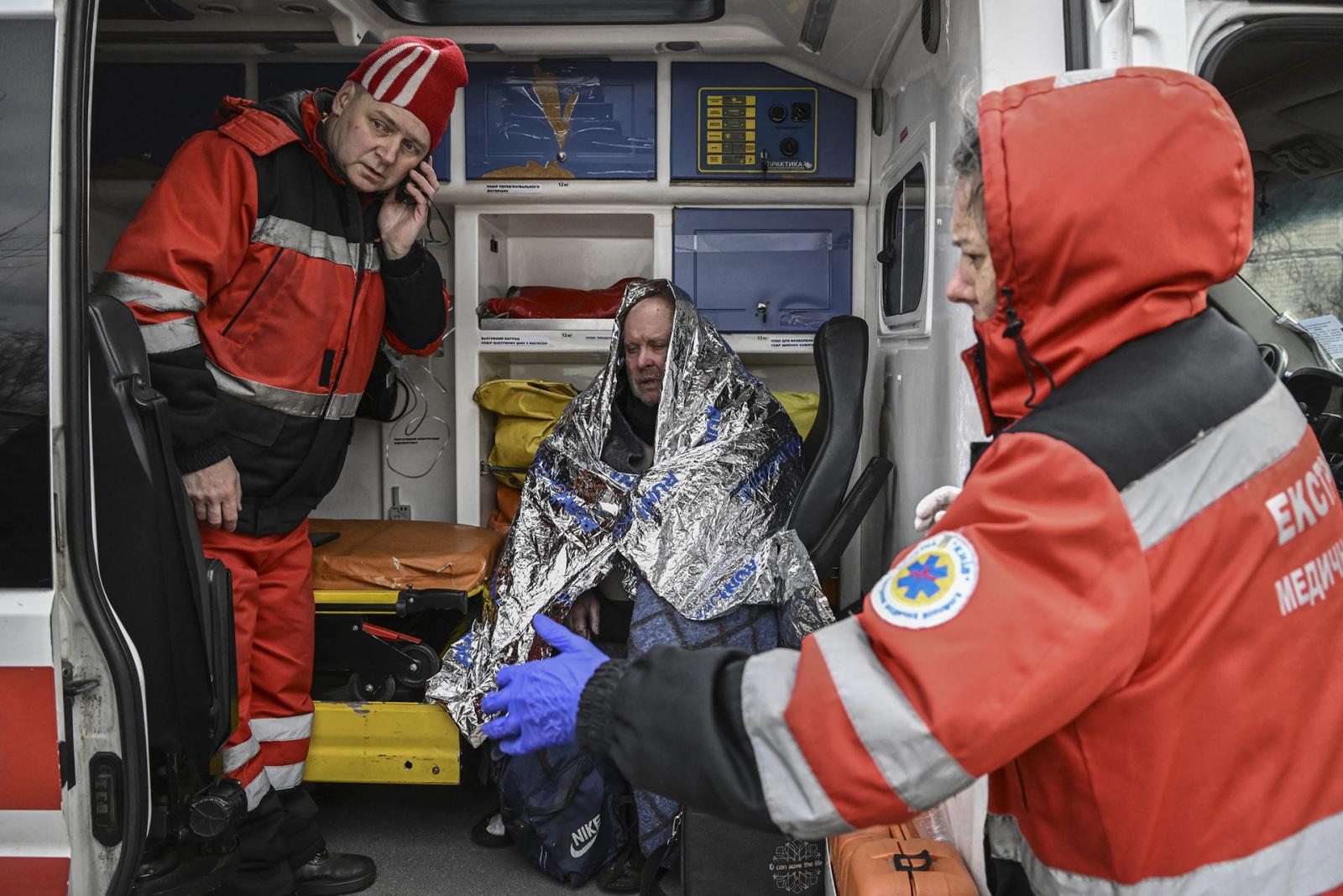 Helyi lakó egy lerombolt lakóház előtt áll Kijev északnyugati Obolon kerületében 2022. március 14-én.