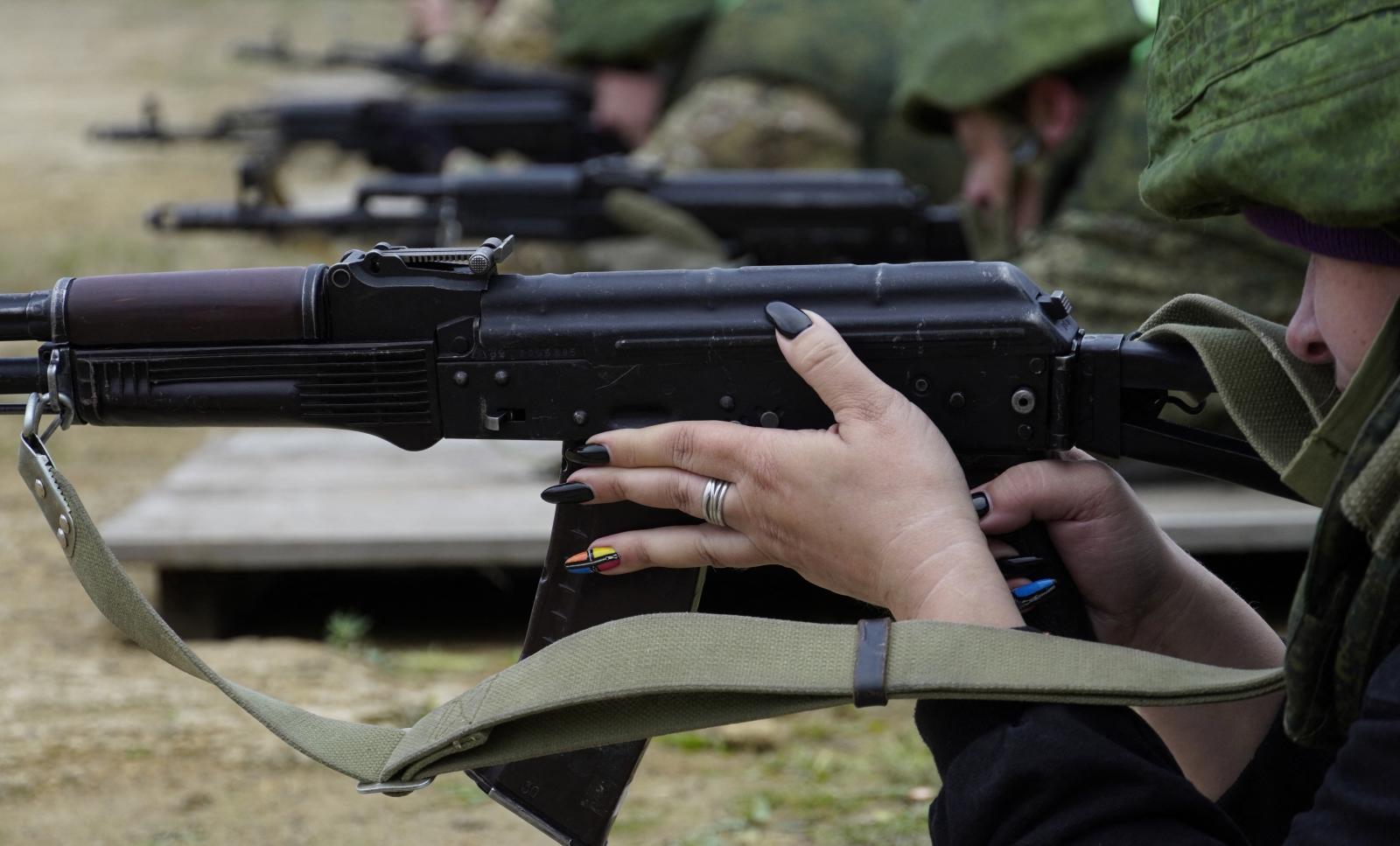 Egy ukrán tüntető tartja a tryzubot, Ukrajna címerét a Szolidaritás Ukrajnával tüntetésen a krakkói Fő piactéren, az ukrajnai orosz invázió 264. napján.