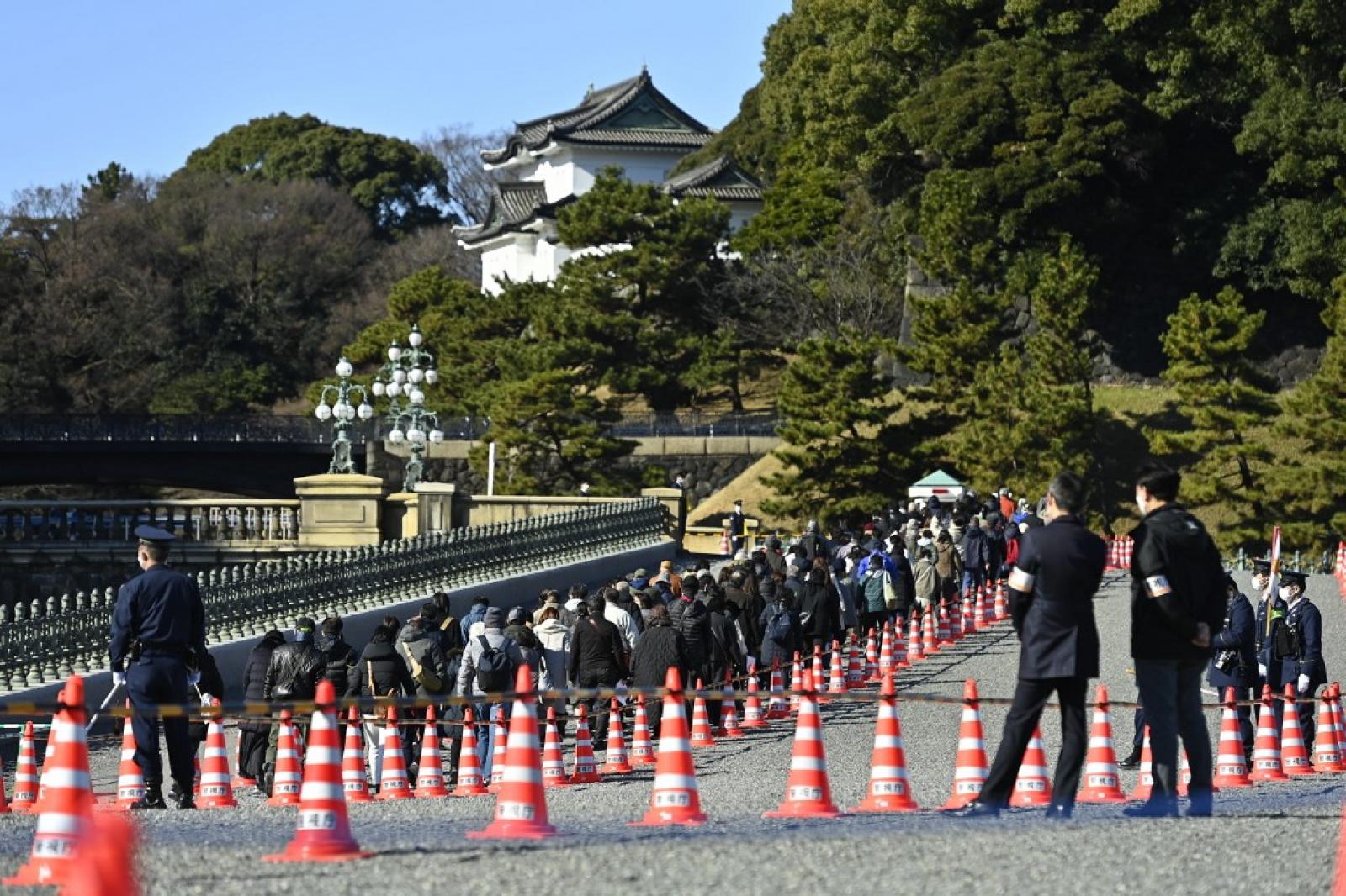 Emberek látogatják a császári palotát, amelyet a japán királyi család újévi nyilvános megjelenése alkalmából nyitottak meg Tokióban, Japánban 2023. január 2-án. 