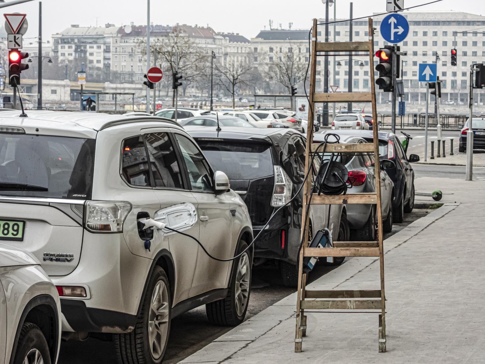 Variációk töltésre: emeleti lakásból kilógatott hosszabbítón az elektromos kocsi. Kevés a töltőoszlop, jönnek a magyar buheramegoldások