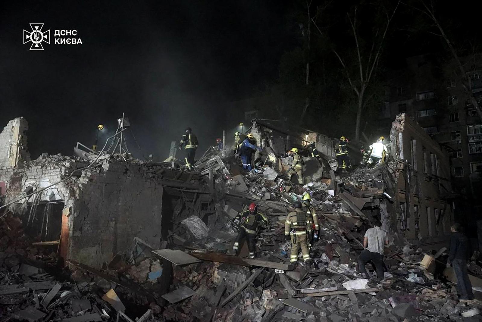 Mentőalakulatok kutatják át egy, az éjszakai rakéta- és dróntámadásban leomlott épület roncsait Kijevben