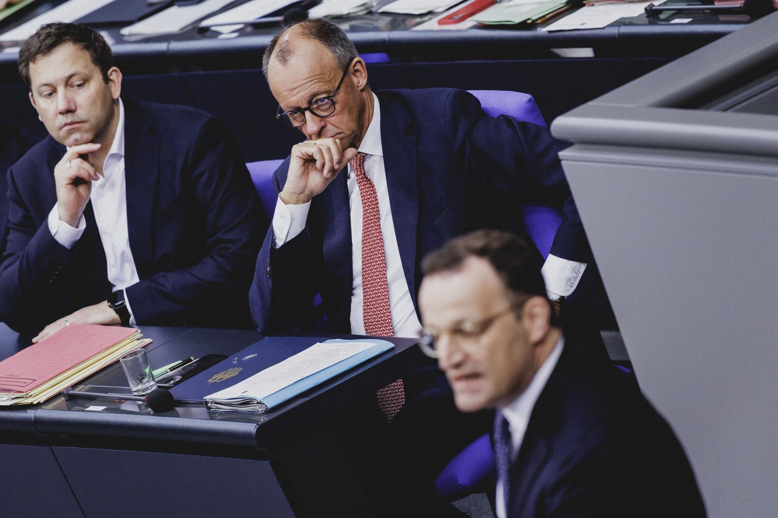 Friedrich Merz (középen) hallgatja Jens Spahn beszédét