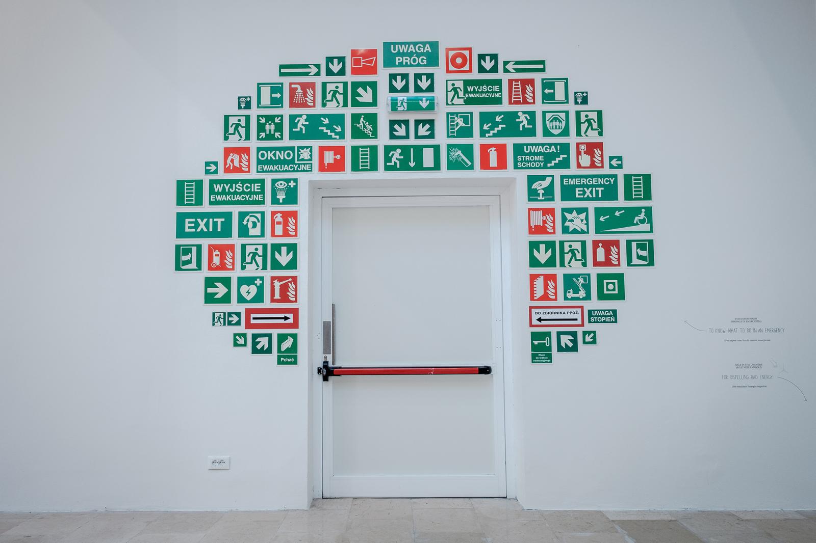 A lengyel pavilon kiállítása nem nélkülözi a humort: egy ajtó felett számos piktogram jelzi, hogy bizony itt van a kijárat