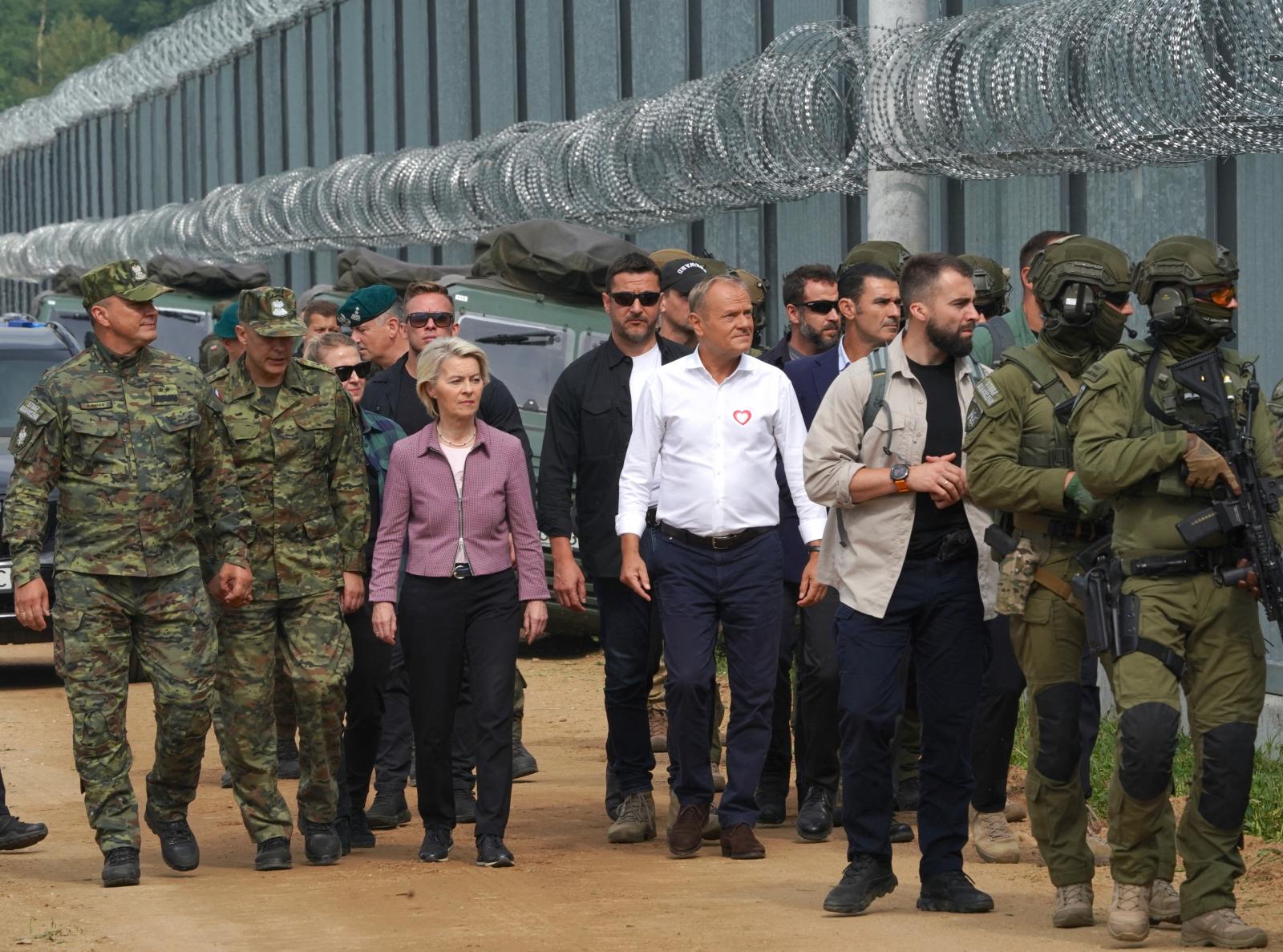 Ursula von der Leyen, az Európai Bizottság elnöke és Donald Tusk, Lengyelország miniszterelnöke a lengyel-fehérorosz határon felállított kerítés előtt.