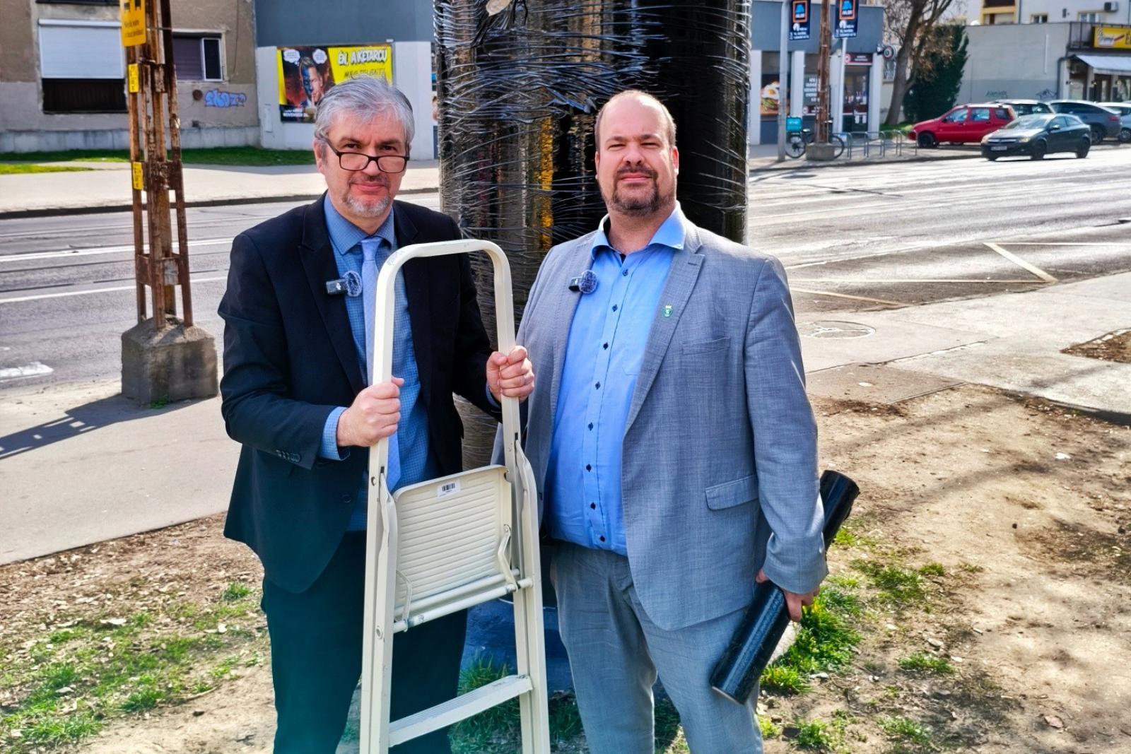 Videón, ahogy Hadházy Ákos és a zuglói polgármester lefóliáz egy hirdetőoszlopot