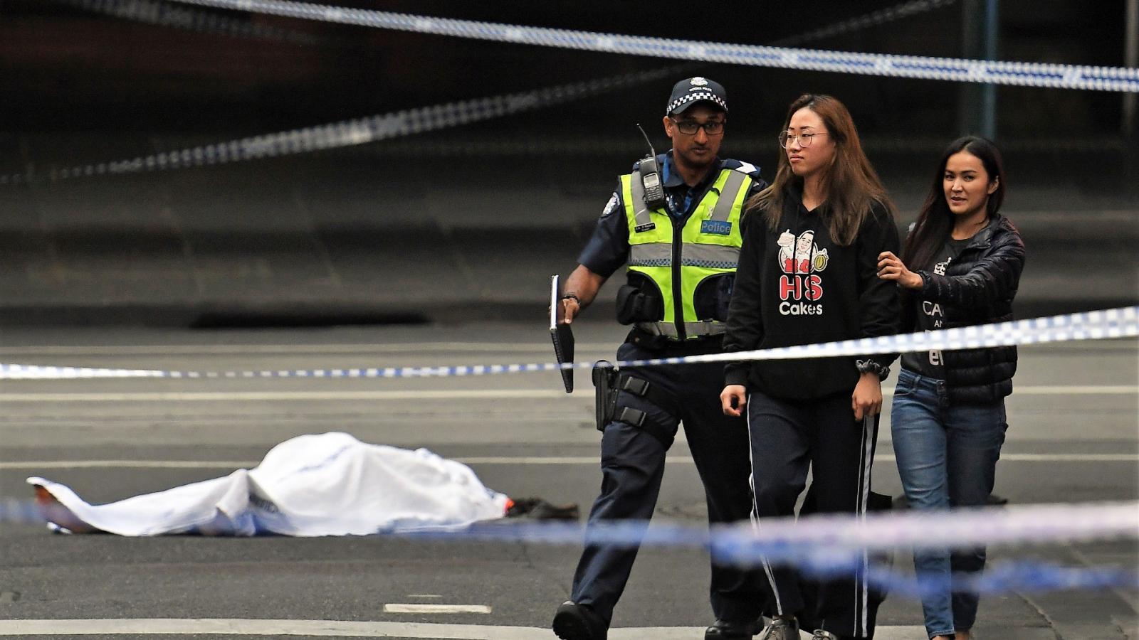 Járókelőt kísérnek ki a rendőrök a melbourne-i vérontás helyszínéről