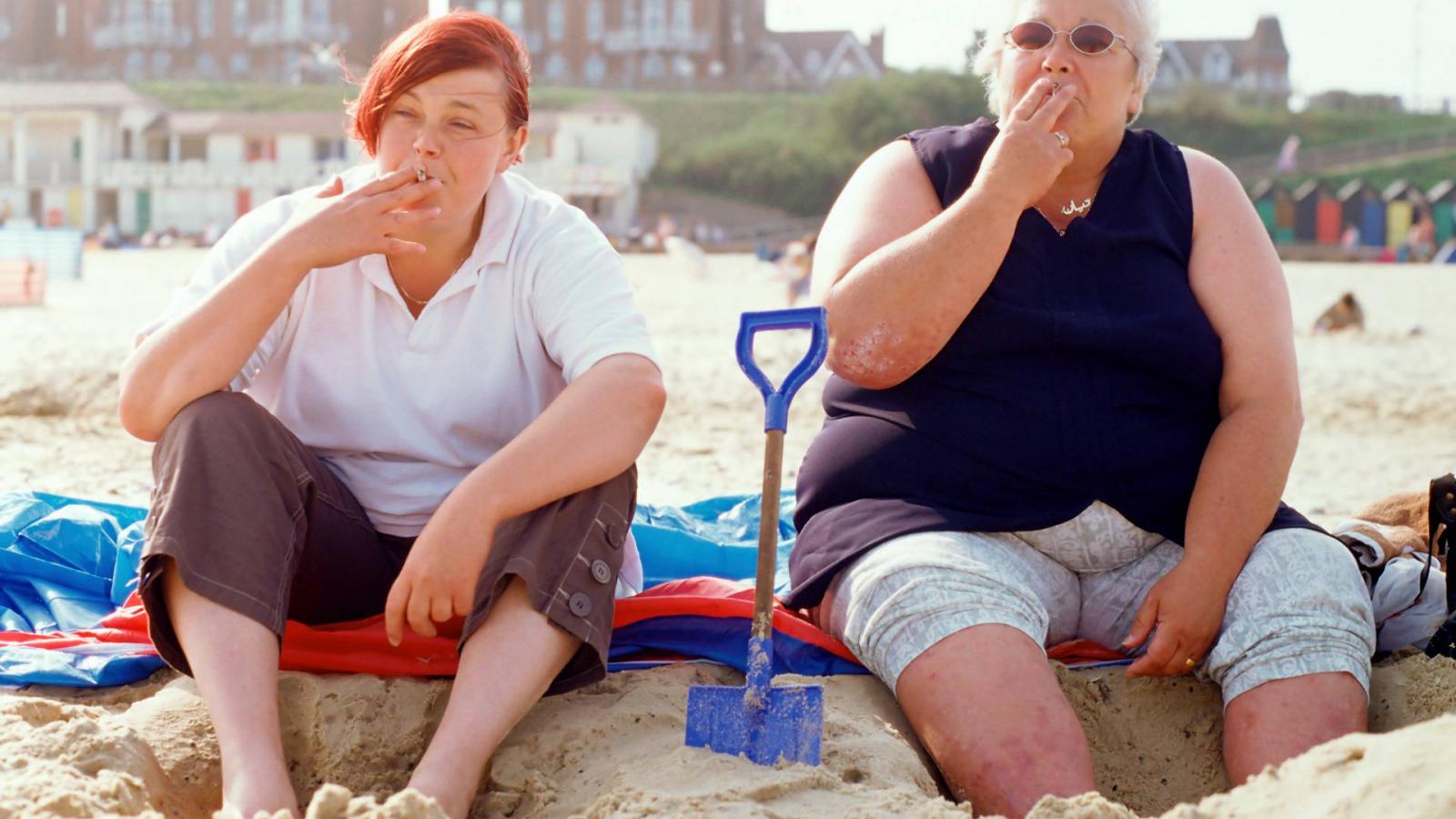 Two women smoking on the beach