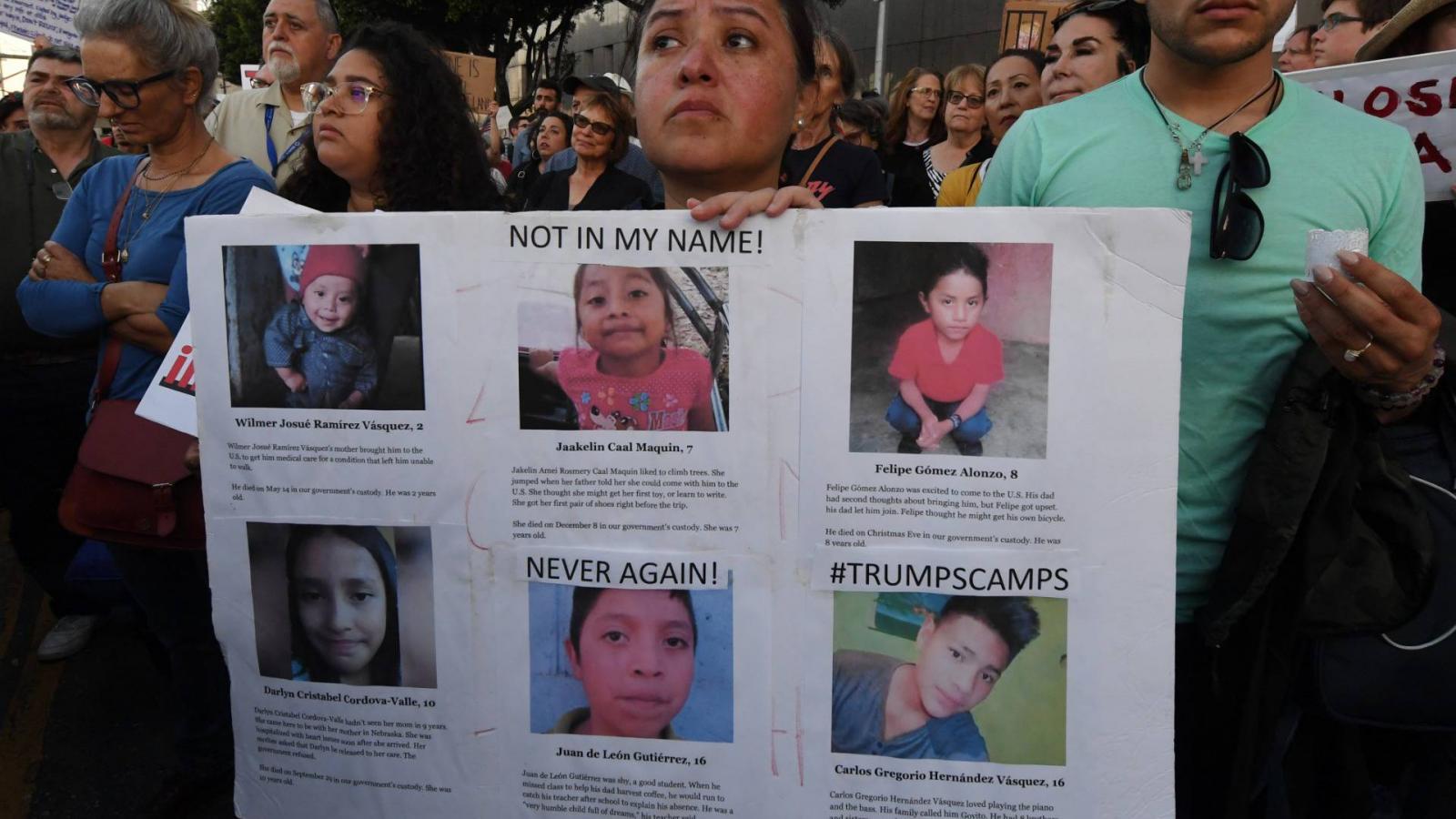 Tüntető tartja az amerikai tranzitzónákban meghalt gyermekáldozazok fényképét 2019. július 12-én, Los Angeles-ben