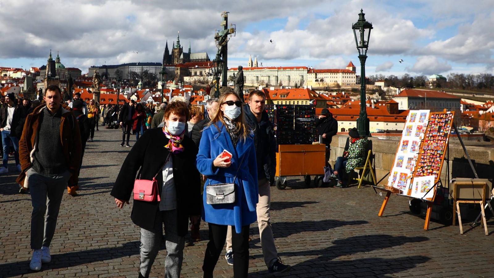 Szájmaszkos turisták a prágai Károly hídon