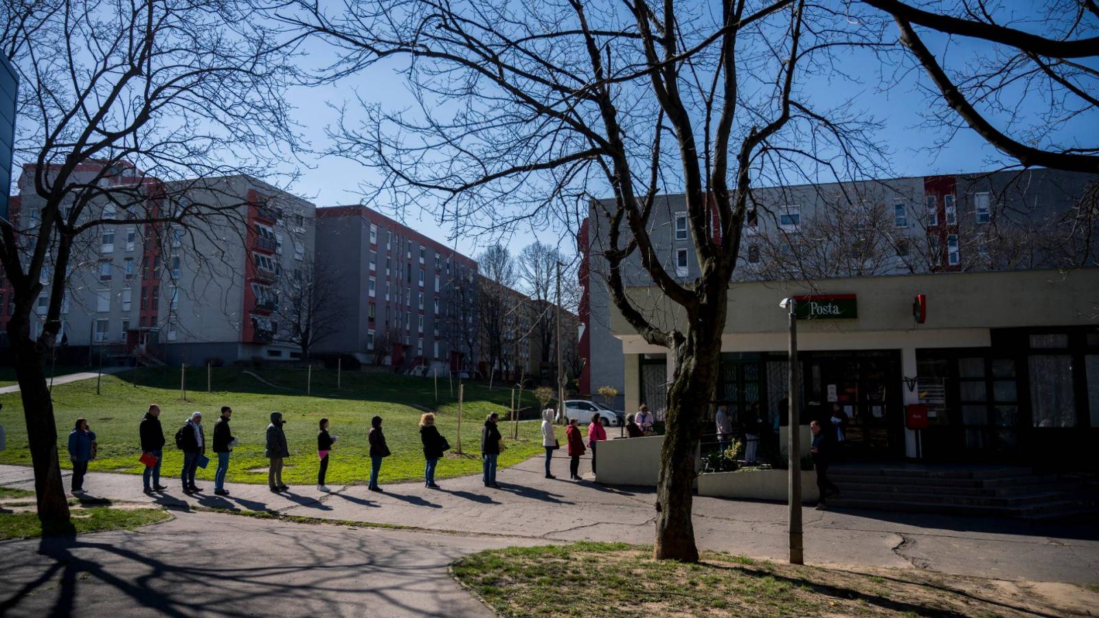 Sorban állók a pécsi 18. számú posta épülete előtt 2020. március 16-án