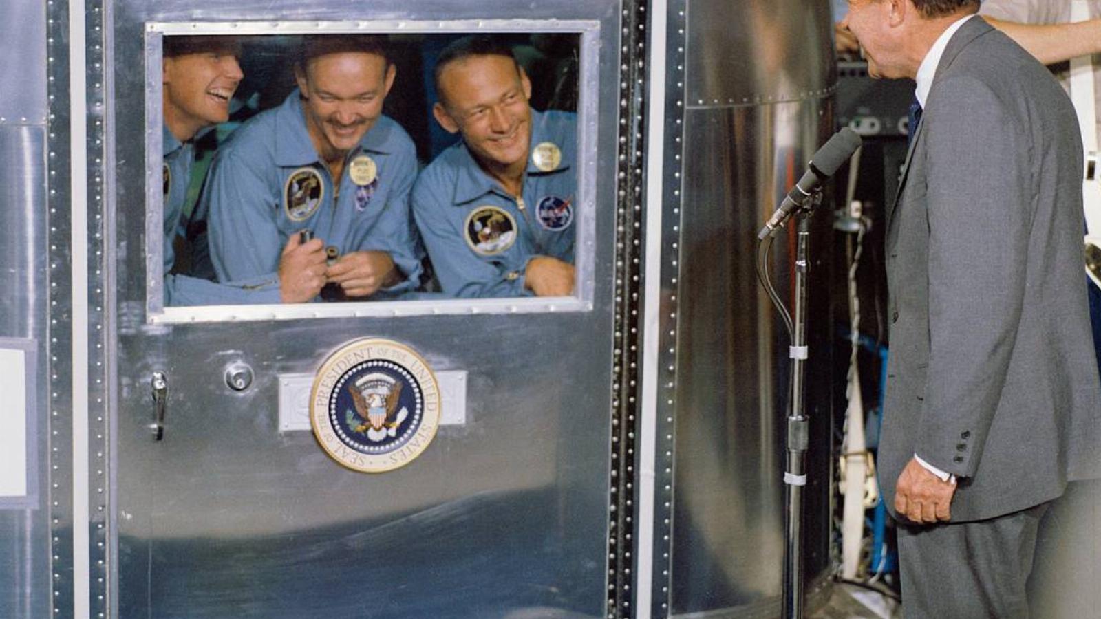 A mobil karanténban fogadják az Apollo–11 űrhajósai Richard M. Nixon elnök üdvözletét a USS Hornet fedélzetén. Balról Neil Armstrong, Michael Collins és Edwin Aldrin