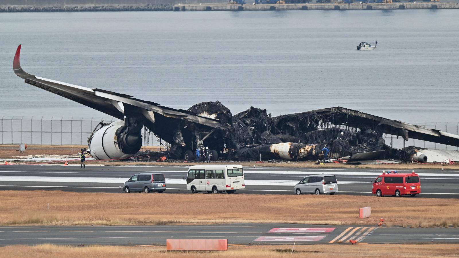 A Japan Airlines utasszállítójának kiégett roncsai a tokiói Haneda nemzetközi repülőtéren 2024. január 3-án