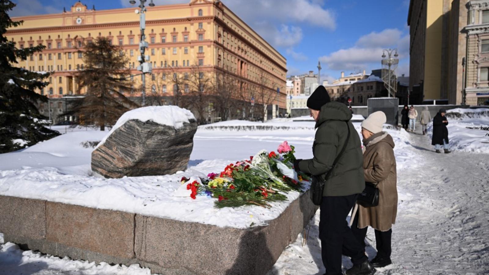  Alekszej Navalnij emléke a Szoloveckij-kőnél, a politikai elnyomás emlékművénél, amely a Navalnij iránti tiszteletadás egyik helyszíne lett, a háttérben az orosz Szövetségi Biztonsági Szolgálat (FSZB) főhadiszállásával Moszkvában 2024. február 20-án.