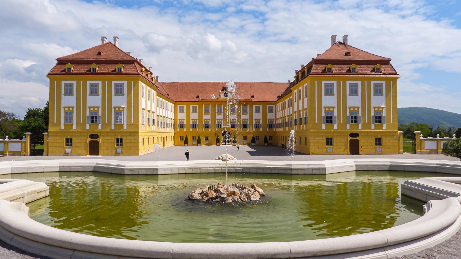 A Schloss Hof kastély barokk épülete, az előtérben a park Neptun-kútja