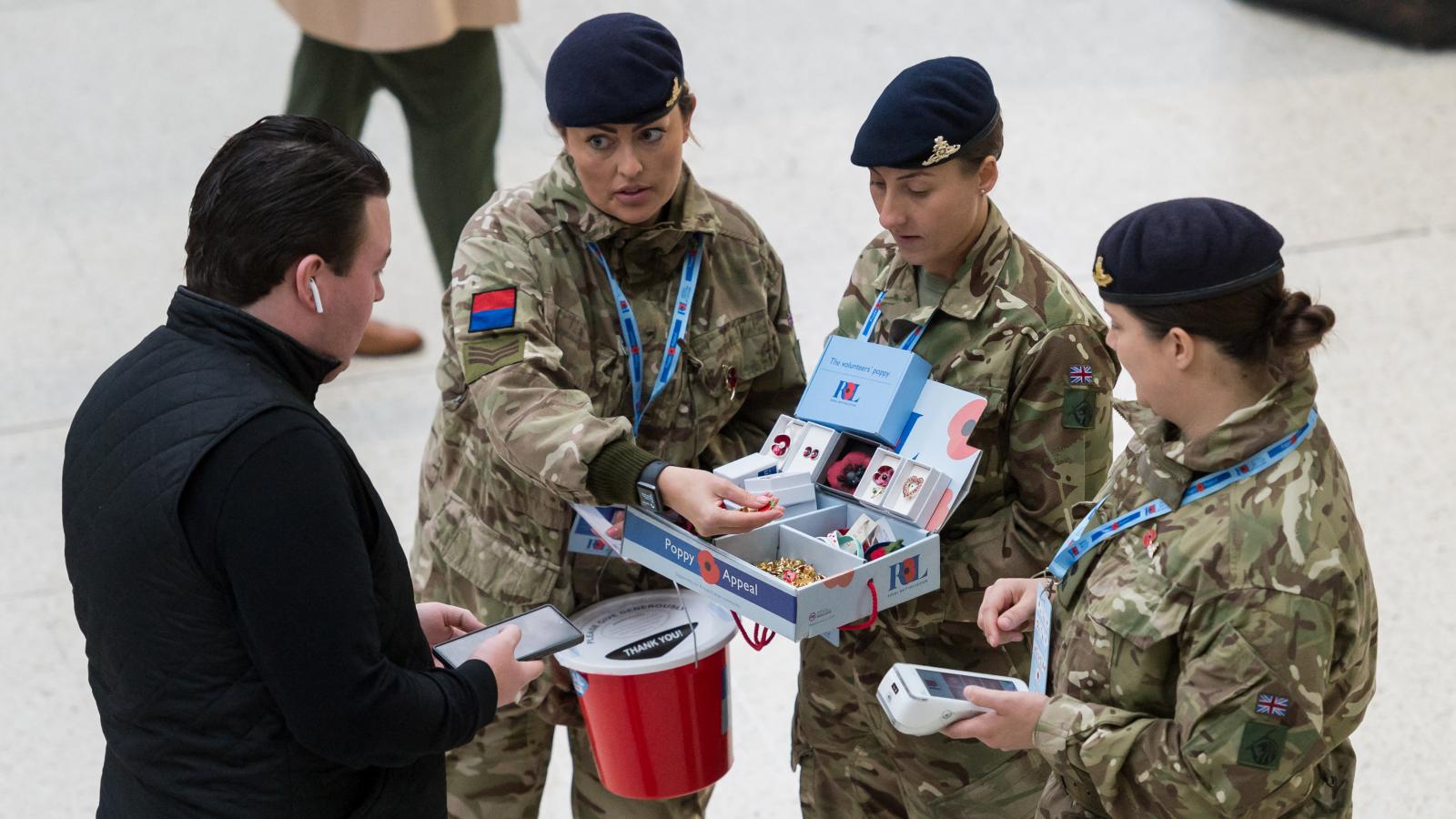 Remembrance Day Londonban. A hősi halottakra való emlékezés napján önkéntesek selyemből készült kitűzhető pipacsokat kínálgatnak 