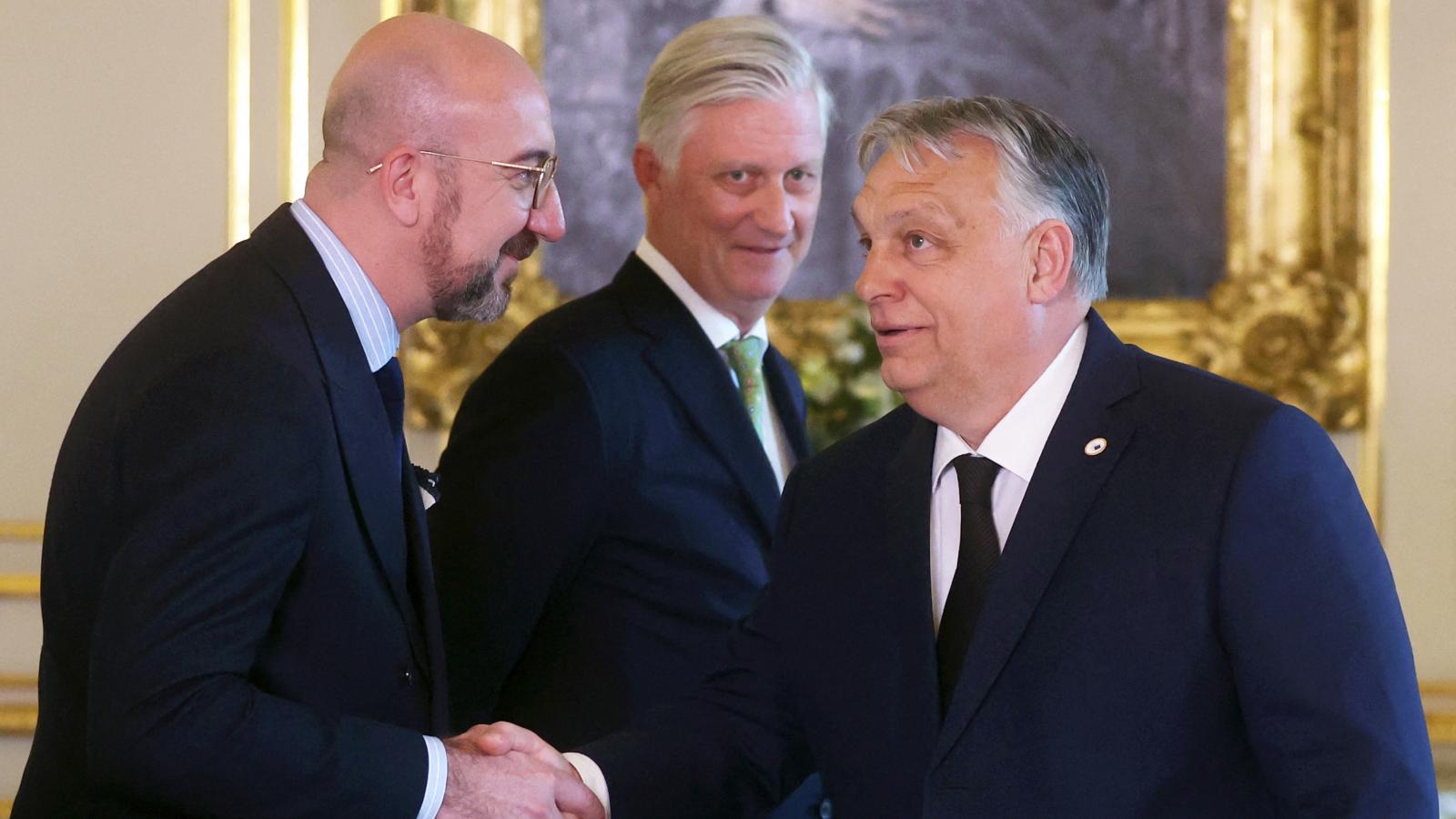 Fülöp belga király figyeli a Charles Michel-el kezet fogó Orbán Viktort Brüsszelben 2024. április 17-én 