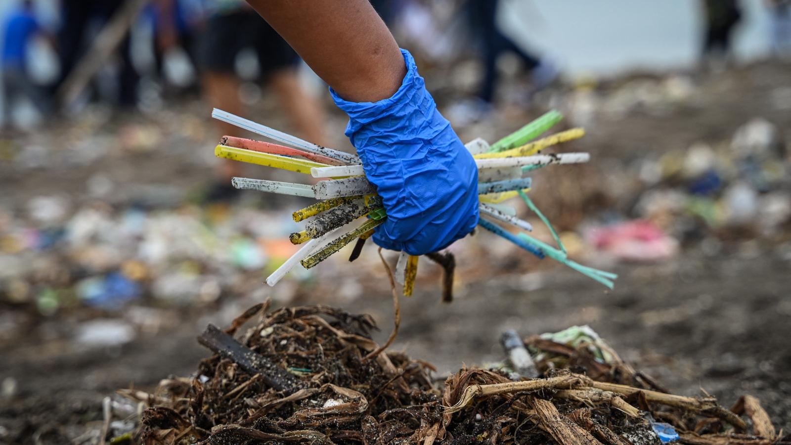 Egy önkéntes eldobott műanyaghulladékot, köztük szívószálakat gyűjt a Fülöp-szigeteki Manilában található Baseco Beachen 2024. szeptember 21-én.