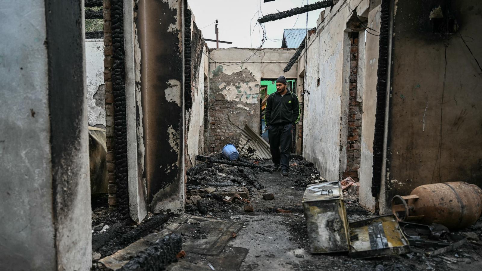 Pakisztáni lövegek által megsemmisült házában sétál egy férfi május 8-án