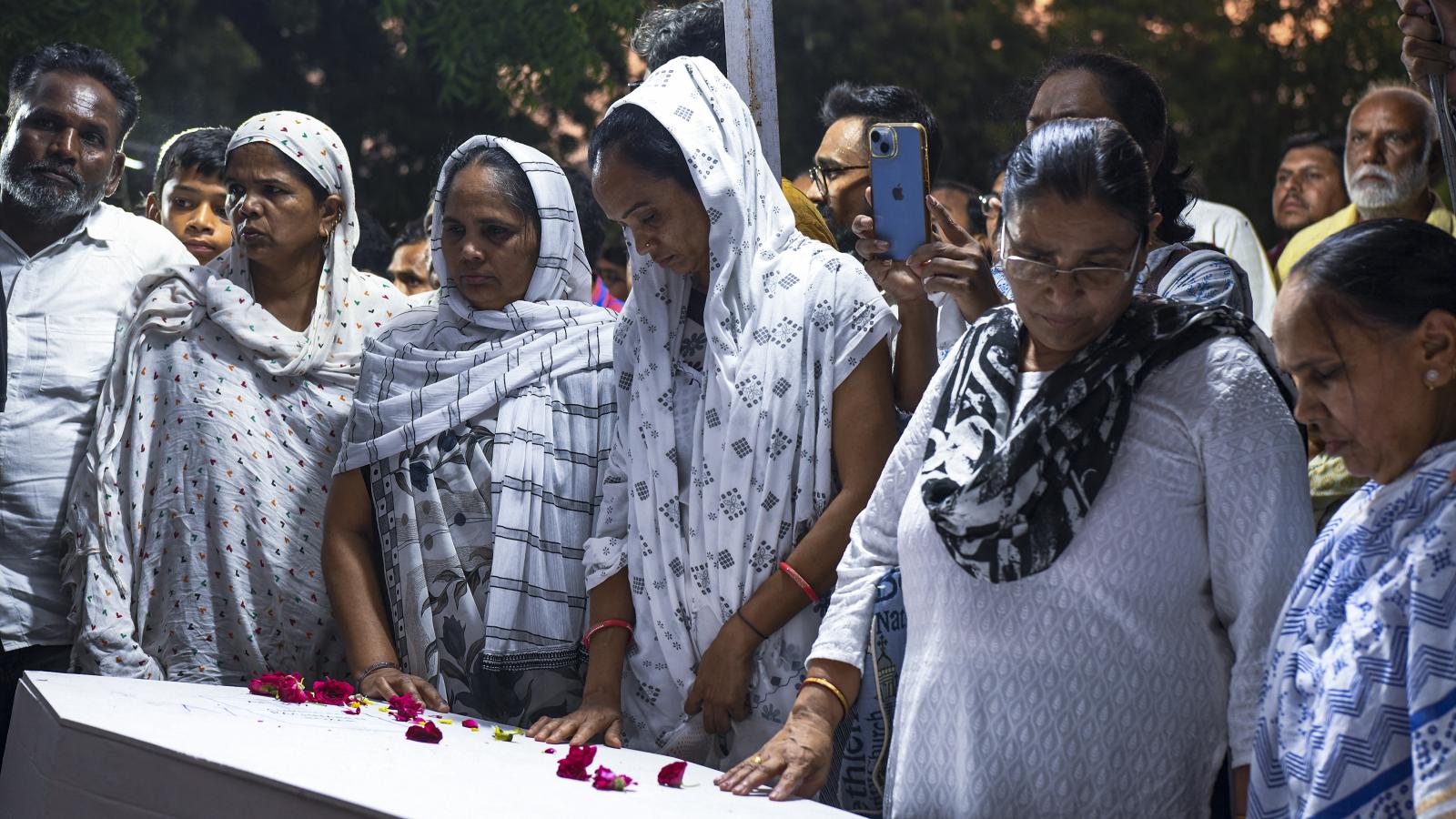 Gyászoló családtagok az egyik áldozat, Rozar David Christian koporsójánál vasárnap Ahmedabadban