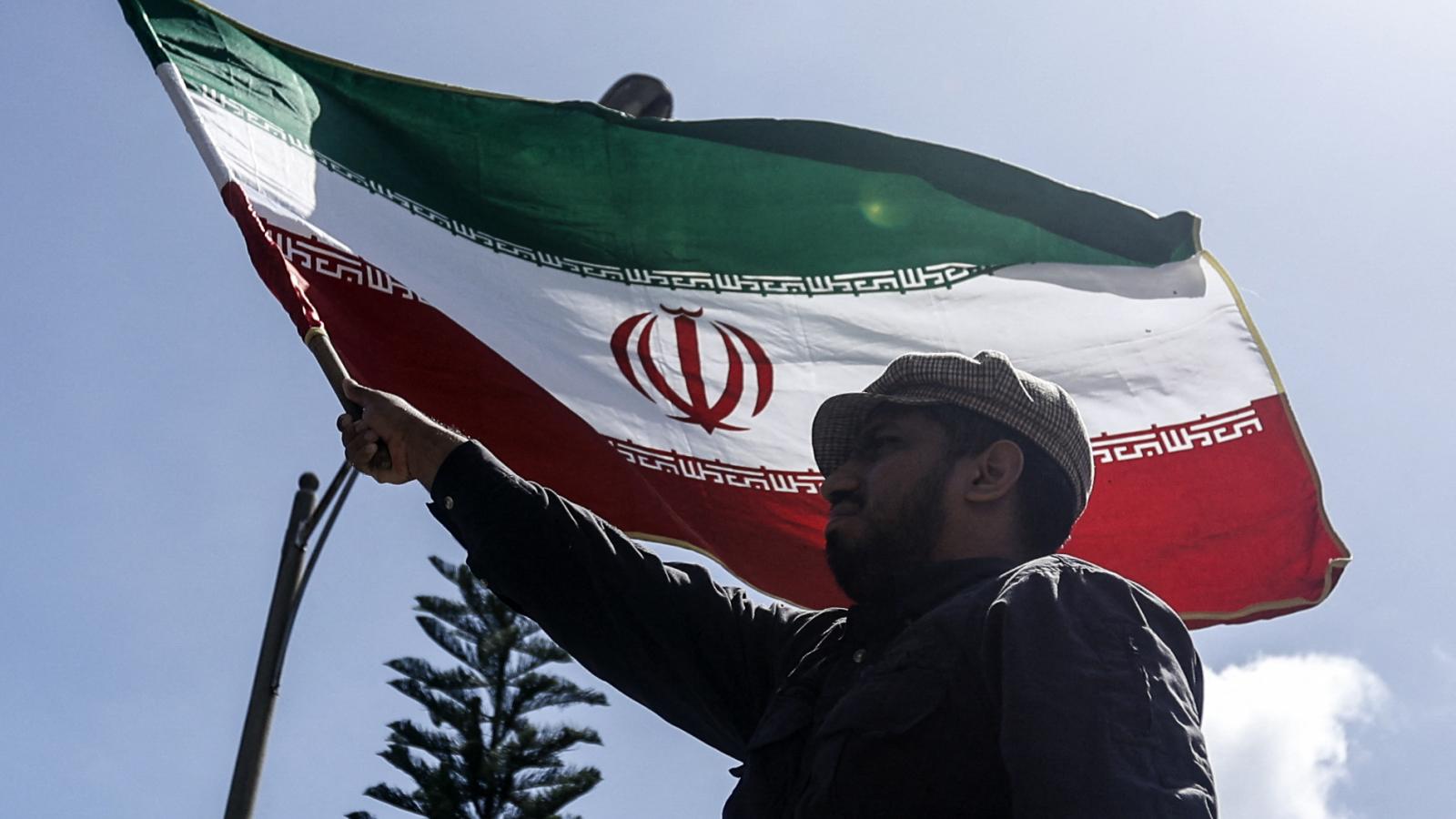 Egy férfi iráni zászlót lenget az iráni caracasi nagykövetségnél 2025. június 17-én