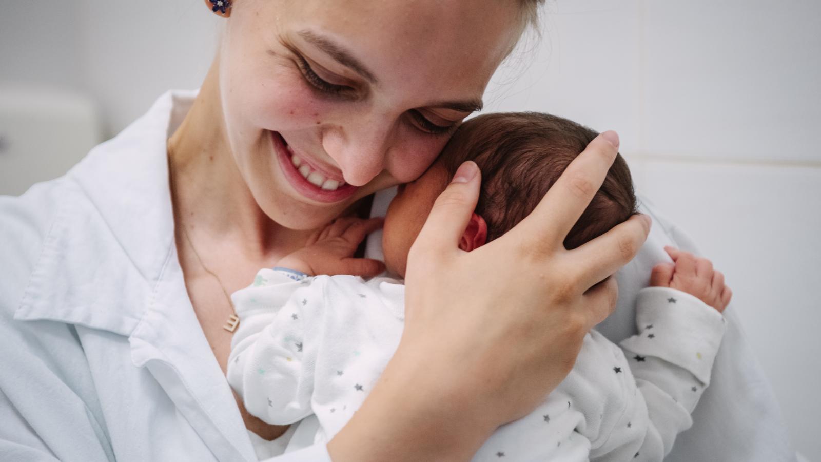 Egyetemista önkéntesek kórházban maradt újszülötteket gondoznak, ringatnak. Fotónkon Kőhalmi Eszter egy kisbabával.