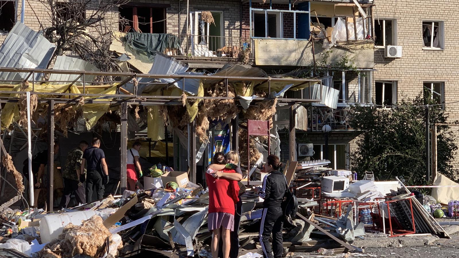 Lakosok egy megrongálódott lakóépület mellett 2025. augusztus 30-án Zaporizzsjában