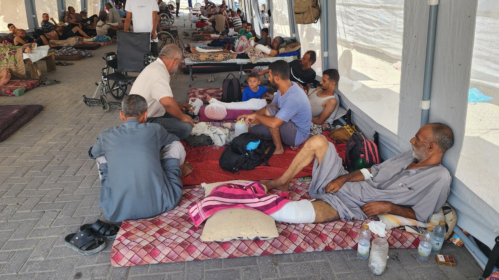 Kezelés alatt álló betegek a Nasser Kórház udvarán felállított rögtönzött sátrakban Khan Yunisban augusztus 18-án 