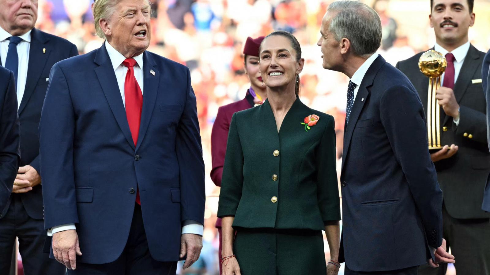 Donald Trump amerikai elnök Mark Crney kanadai miniszterelnökkel az spamyol-argentin vb-döntő utáni átadási ünnepségen. Kettejük között Claudia Sheinbaum mexikói államfő