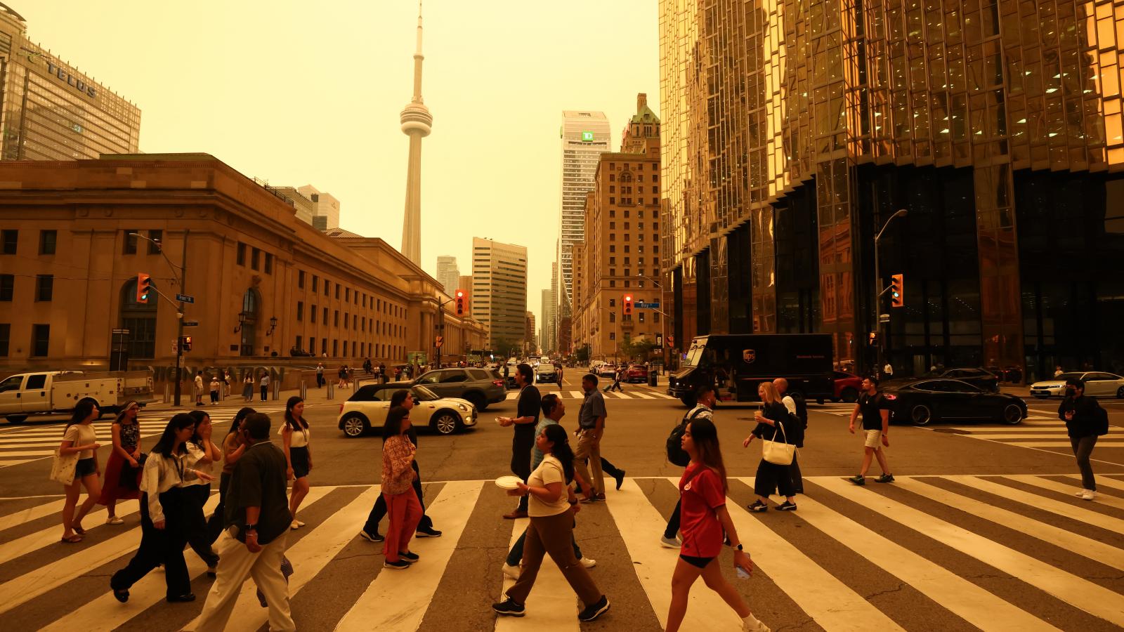 Emberek sétálnak Toronto belvárosában, 2026. július 15-én, miközben az észak-ontariói erdőtüzek füstje rossz levegőminőséget okoz a városban