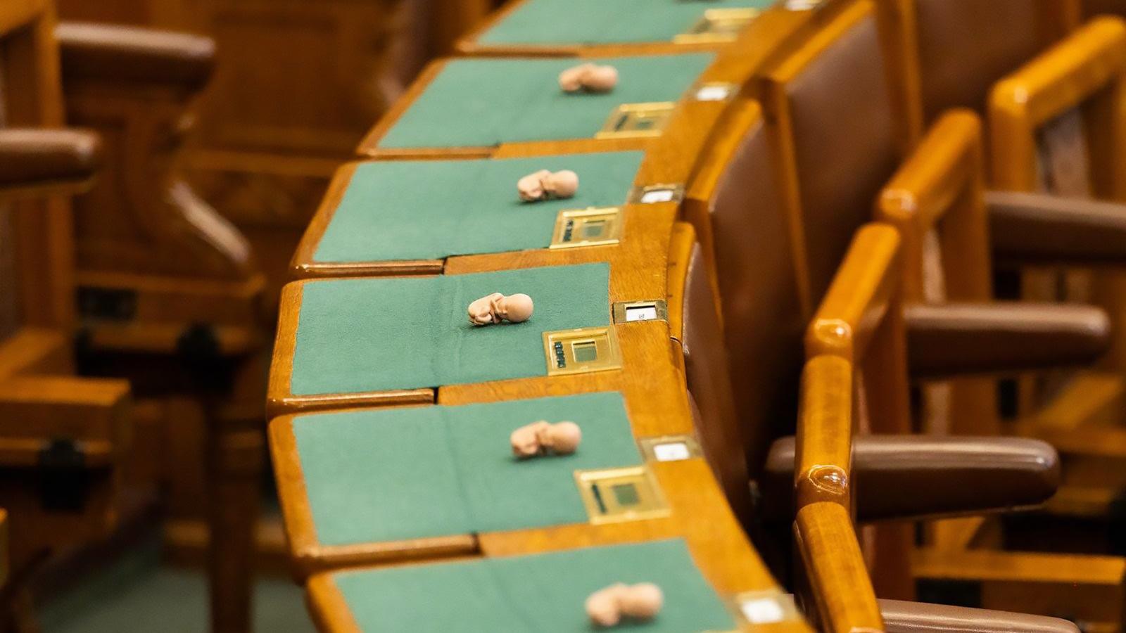 Műanyag magzatok a képviselők asztalain a parlamenti ülés kezdete előtt 2026. július 6-án