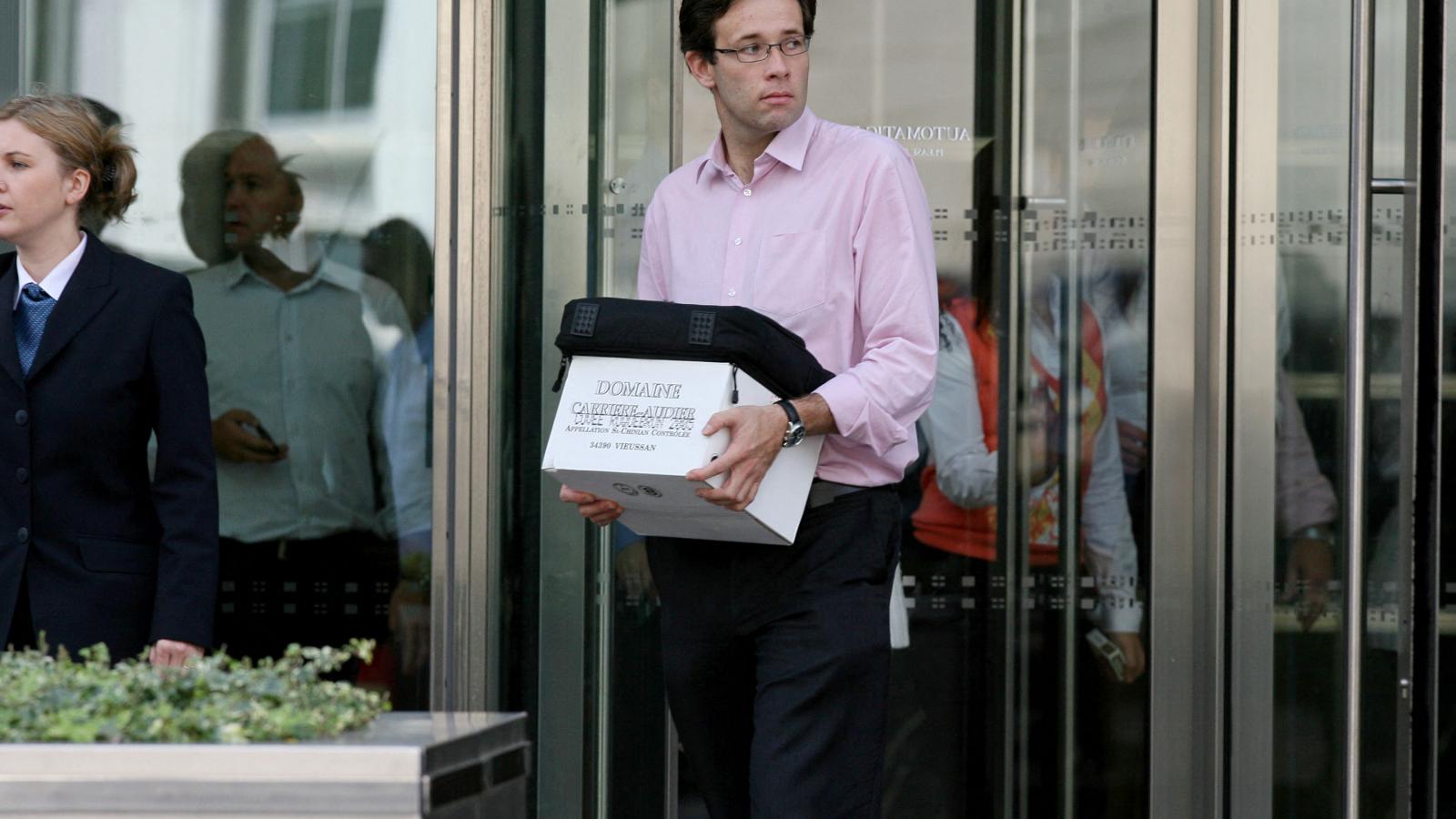 Egy dobozzal a kezében lévő férfi elhagyja a Lehman Brothers európai központját a kelet-londoni Canary Wharf-on, 2008. szeptember 15-én