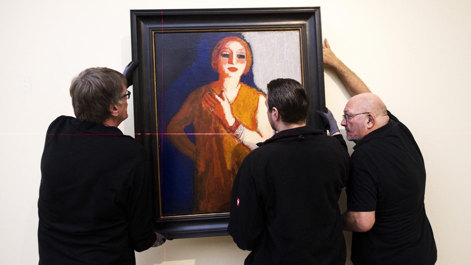 A dolgozók éppen Kees van Dongen holland-francia festőművész egyik alkotását helyezik el a lareni Singer Laren múzeumban