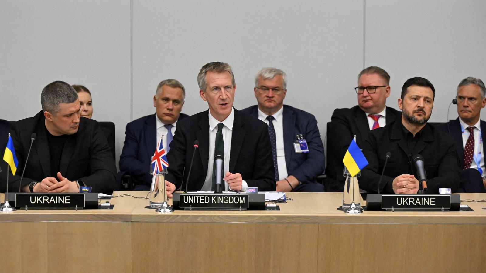 Mihajlo Fedorov és Volodimir Zelenszkij feszülten hallgatja Dan Jarvis (középen) brit védelmi minisztert 2026. június 16-án Brüsszelben egy NATO-tanácskozáson