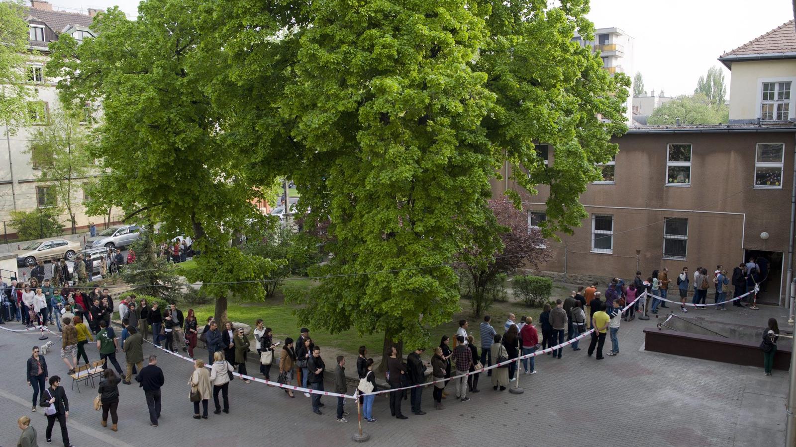 Átjelentkezők állnak sorba a Bocskai út és Nagyszőlős utca sarkánál, az újbudai Bocskai István Általános Iskola épületében kiala