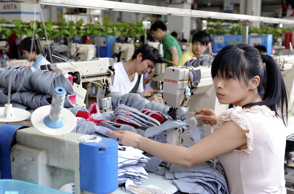 Munkások dolgoznak Kína legnagyobb sportcipő gyártója, az Anta üzemében, a délkeleti Csincsiangban 2014. április 18-án. A kínai cipőipar nem érzi a globális gazdasági válságot. Fotó: Trebitsch Péter/MTI