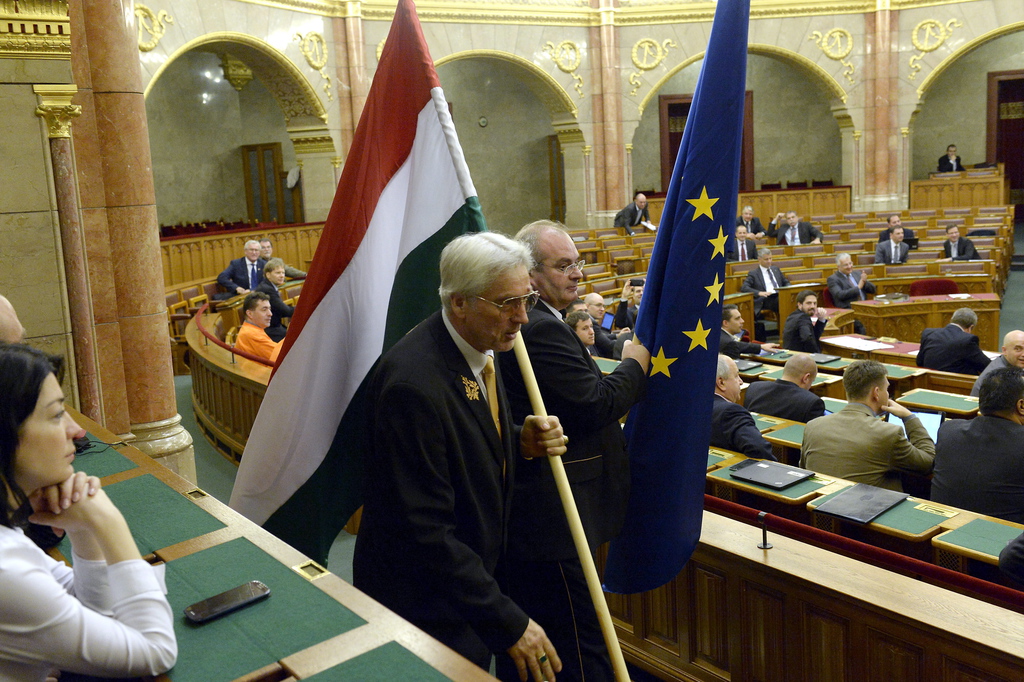 A szocialista képviselők által elhelyezett nemzetiszínű és uniós zászlót terembiztosok eltávolítják az ülésteremből az Országgyűlés plenáris ülésén. MTI Fotó: Soós Lajos