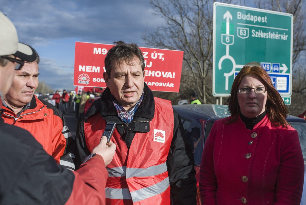 Kurtyán Ferenc, az MSZP Szekszárdi elnöke, Király József, a párt Bács-Kiskun megyei elnöke és Heringes Anita MSZP-s országgyűlési képviselő, az MSZP tolna megyei elnökhelyettese (b-j) sajtótájékoztatót tart az M9-es autóút fizetőssé tétele miatti forgalomlassító demonstráción és félpályás útlezáráson a 6-os főút M9-es autóútra vezető szakaszán, Szekszárd közelében 2015. január 12-én. MTI Fotó: Ujvári Sándor