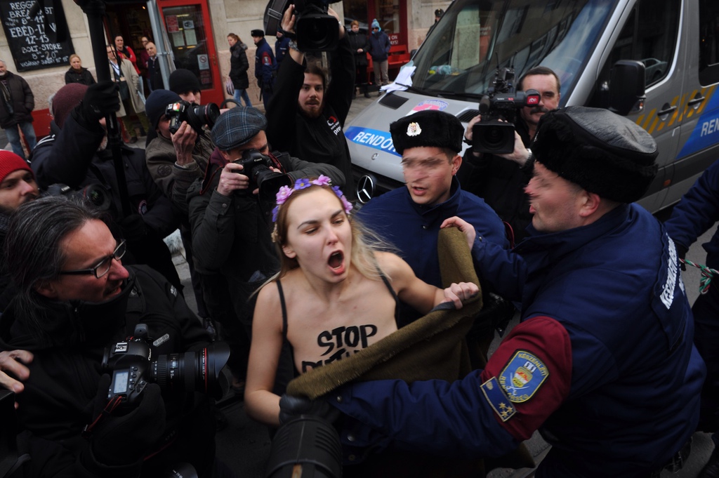 Rendőrök viszik el a Femen-aktivistát. FOTÓ: Tóth Gergő/Népszava