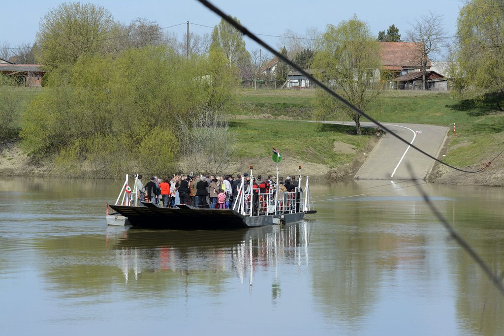 A vendégek kipróbálják a Nagyrév és Tiszabög között közlekedő kompot az átadás után 2015. április 10-én.  MTI Fotó: Mészáros János